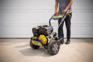 a man standing next to a yellow and black lawn mower.